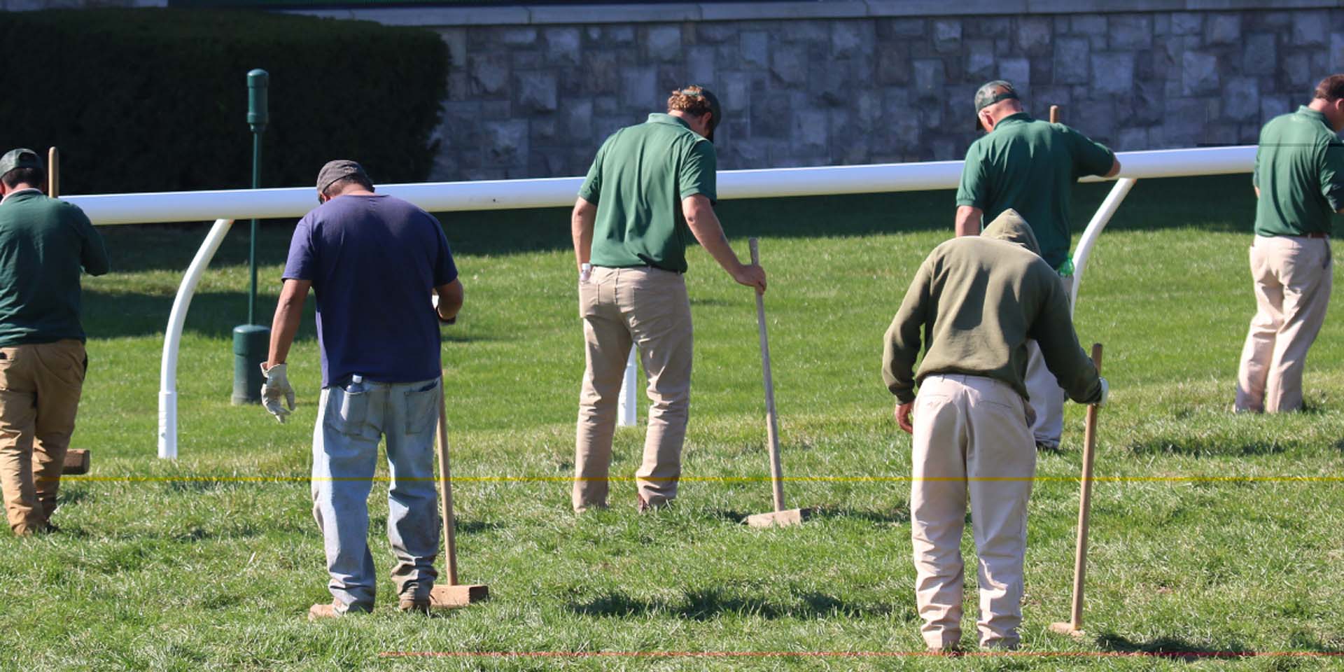 An action shot of Racecoltvalley team members tamping down turf divots.